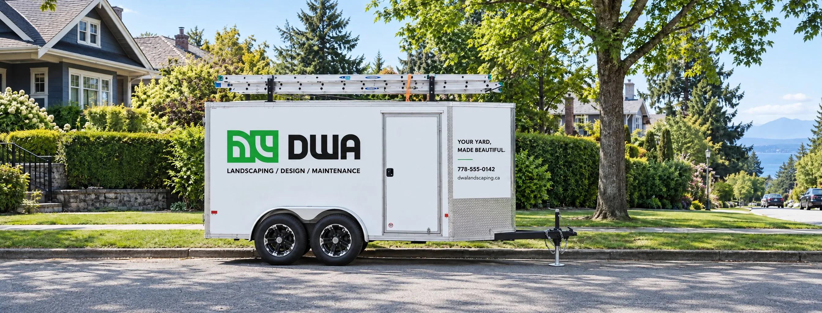 DWA Landscaping branded enclosed trailer parked on a residential street