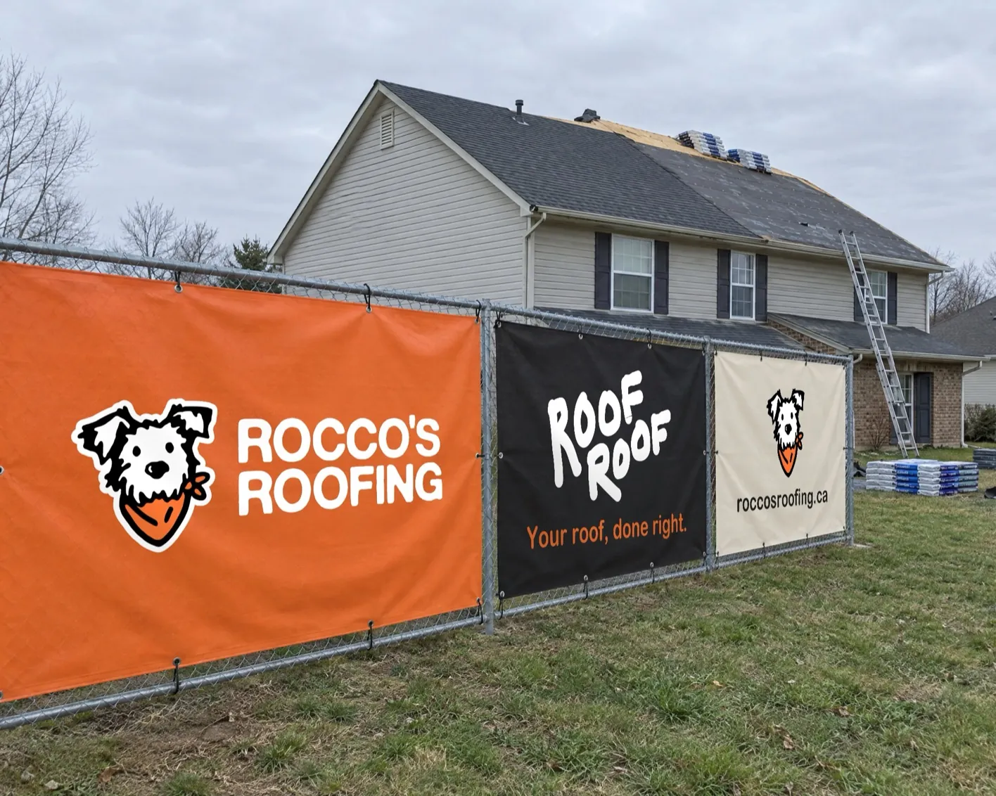 Rocco's Roofing branded mesh fence banners on a job site fence